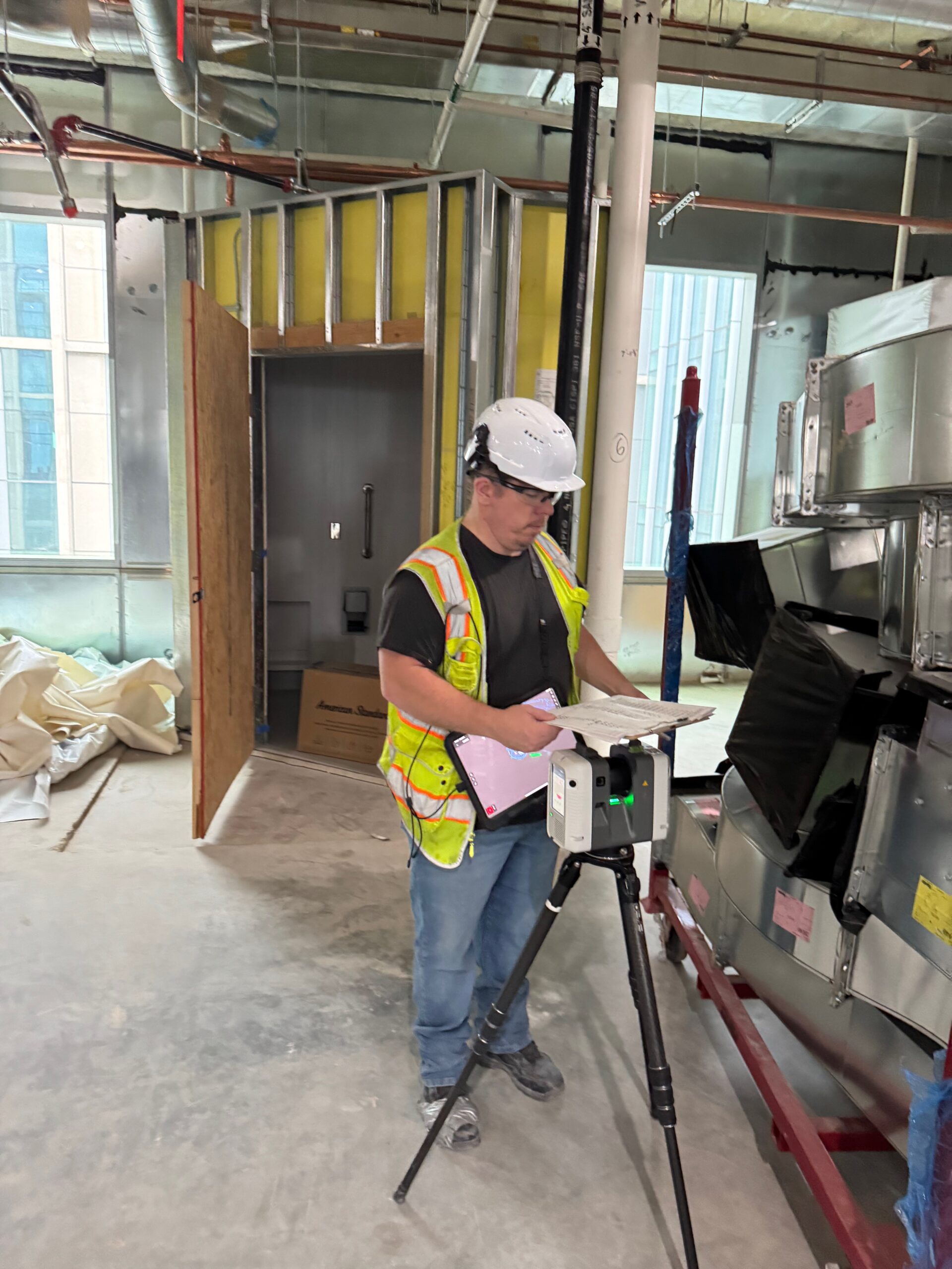 Worker surveying construction site with equipment